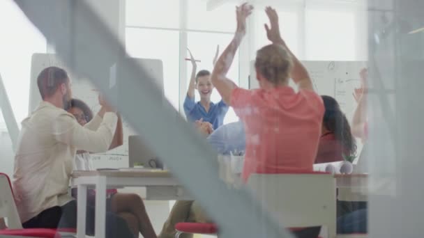 Via glazen mensen applaudisseren kantoor. Succesvolle collega 's vieren feest. — Stockvideo