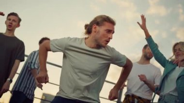 Yakışıklı adam alacakaranlıkta partide eğleniyor. Dans eden insanlar parti yapıyor.. 
