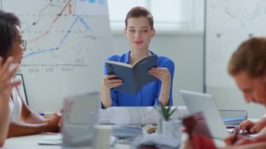 Patroniçe toplantı odasında günlük tutuyor. İş arkadaşlarıyla plan yapan kadın.. 