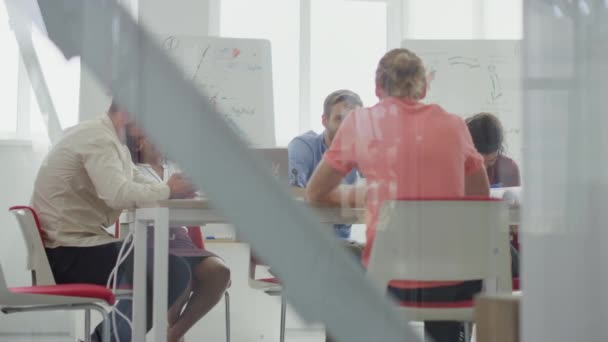 Genom glas människor sitter bord styrelserum. Kollegor möte modernt kontor. — Stockvideo