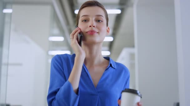 Piękna dziewczyna rozmawiająca przez telefon w biurze. Radosna bizneswoman uśmiechnięta koleżanka — Wideo stockowe