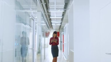 Modern ofiste tablet üzerinde çalışan Afrikalı bir kız. İş kadını kameraya poz veriyor