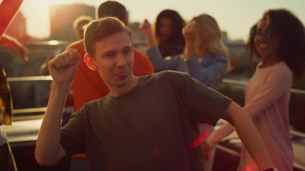 Fröhlicher Typ, der auf einer Stadtparty tanzt. Freunde amüsieren sich in der Disco bei Sonnenuntergang. — Stockvideo