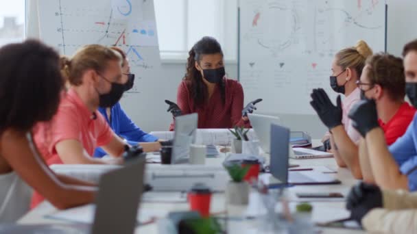 Pessoas mascaradas a falar no escritório. Colegas multiétnicos trabalhando em novo normal — Vídeo de Stock