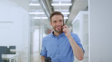 Ofiste telefonla konuşan neşeli bir adam. Neşeli iş adamı gülümseyen meslektaşım.