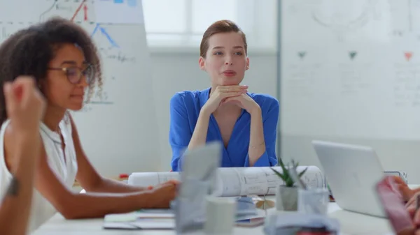 หญิงธุรกิจคุยกันที่ออฟฟิศ เจ้านายหญิงนั่งโต๊ะเพื่อนร่วมงาน — ภาพถ่ายสต็อก