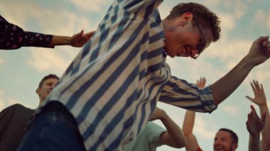 Genç adam açık hava partisinde ortalığı sallıyor. Diskoda dans eden neşeli insanlar. 