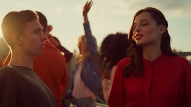 Kısa adam ve uzun kız partide eğleniyorlar. Çatıda dans eden mutlu çift.