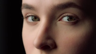 Stüdyoda solda ciddi bir kadın yüzü var. Çekici kız poz veriyor.