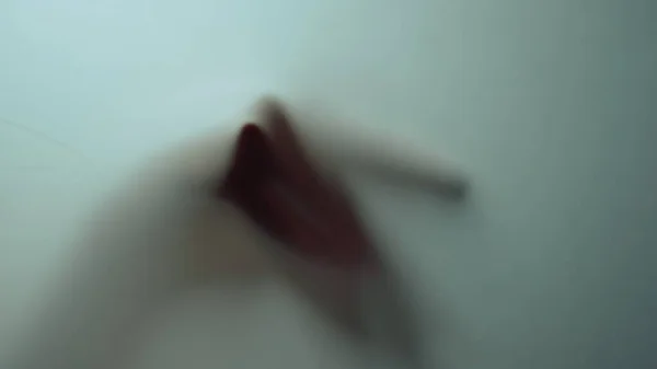 Macro vidéo d'une main féminine se déplaçant derrière un verre givré. Ombre à main. — Photo