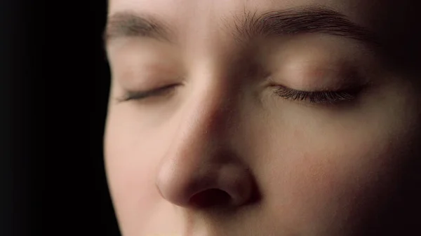 Macro of female face beauty resting with closed eyes in black studio.Tired woman — Stock Photo, Image