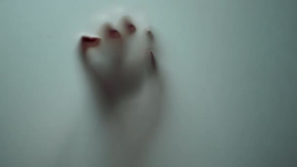 Sombra de mano hembra macro deslizándose hacia abajo en la superficie de vidrio. Horror místico. — Vídeo de stock
