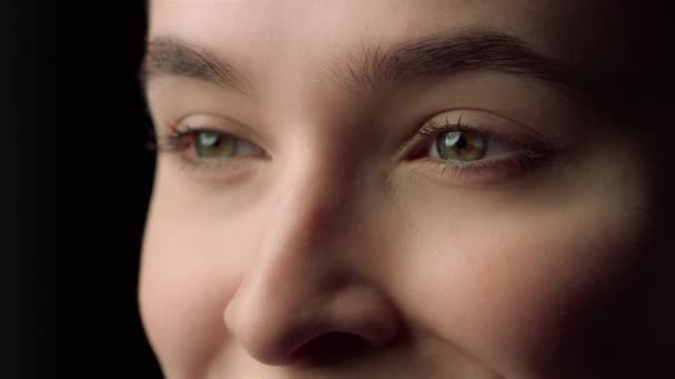 Retrato de cara femenina feliz sonriendo en fondo negro. Chica feliz en el estudio — Vídeo de stock