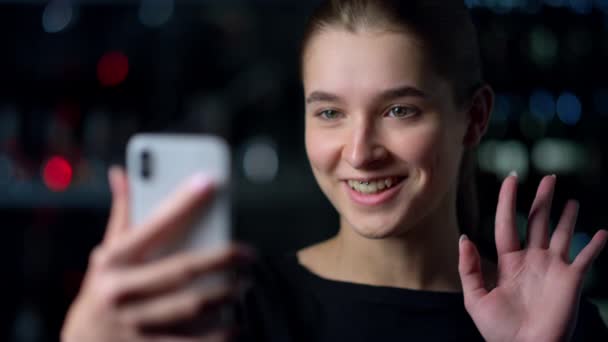 Närbild av vackra flicka med videosamtal med iPhone utomhus.Video chat. — Stockvideo