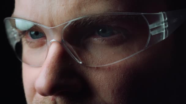 Close-up van gezicht van gefocuste man openen mooie blauwe ogen met bril. — Stockvideo
