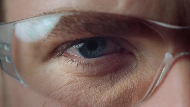 Macro de olho azul masculino aberto usando óculos. Belos detalhes do olho humano. — Vídeo de Stock