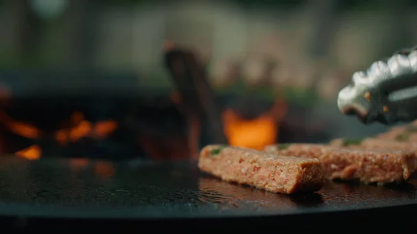 Chef mãos usando fórceps para virar carne fora. Homem colocando carne kebab — Fotografia de Stock