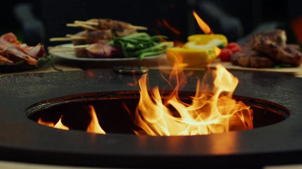 Grill ficando quente para cozinhar comida lá fora. Fogo chamas queimando na churrasqueira — Fotografia de Stock