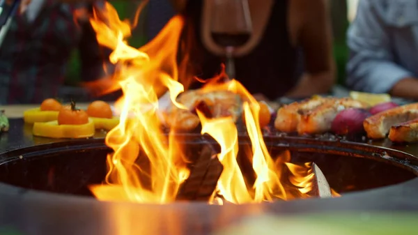 Fechem chamas de fogo queimando na churrasqueira no quintal. Vegetais cozinhar ao ar livre — Fotografia de Stock