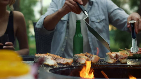 Desconhecido cara preparando bbq peixe lá fora. Homem chef processo de cozimento acabamento — Fotografia de Stock