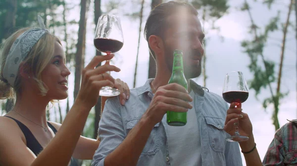 Amigos felizes batendo óculos ao ar livre. Companheiros bebendo álcool lá fora — Fotografia de Stock