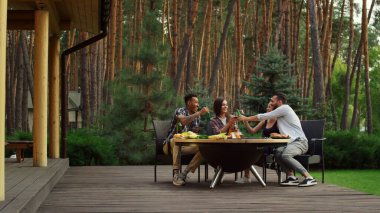 Gençler dışarıda sohbet ediyorlar. BBC Grill 'in etrafında dinlenen arkadaşlar