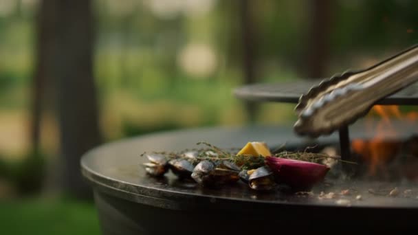 Un tipo desconocido tomando mariscos de grado. Manos de hombre recogiendo mejillones de la parrilla — Vídeo de stock