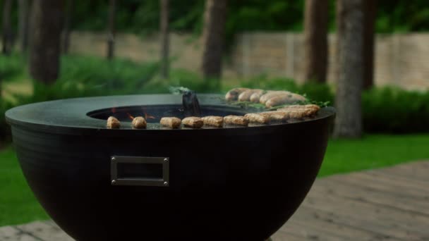 Vue latérale sur le gril du bol à l'extérieur. Bâtonnets de viande grillades sur le gril pour barbecue partie — Video