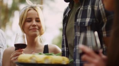 Dışarıda elinde şarap kadehi tutan güzel bir kadın. Bir kadın Fransız fasulyesini dışarı çıkarıyor.