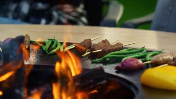 Salsichas Bbq grelhar na churrasqueira ao ar livre. Carne em paus dourando na grelha — Vídeo de Stock