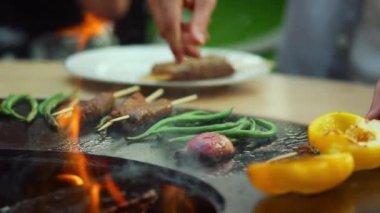 Dışarıda BBC yemeği yiyen arkadaşlar. Erkek ve kadın, Bbbq Grill 'den yemek alıyor.