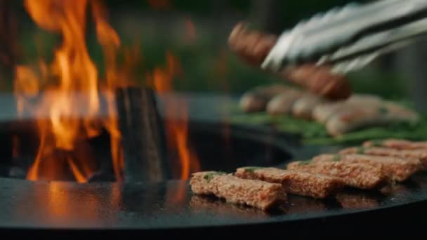 Hombre desconocido preparando kebab de carne en la parrilla en el patio trasero. Hombre chef usando fórceps — Vídeo de stock