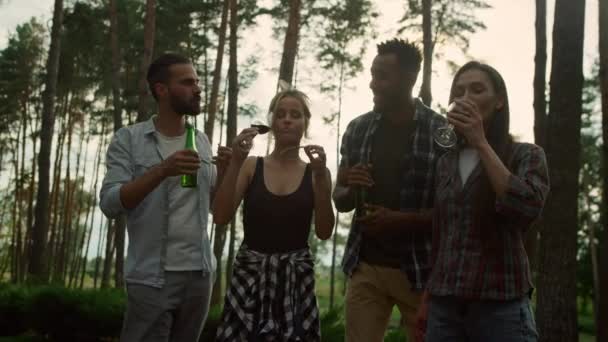 Een jonge vrouw die buiten bonen eet. Ontspannen kerels die bier en wijn drinken — Stockvideo