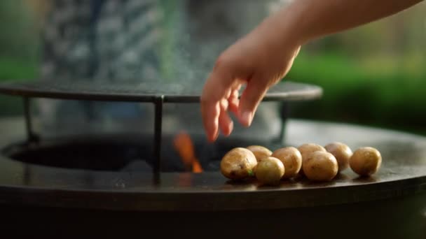 Čerstvé brambory vařící venku na grilu BQ. Muž připravuje brambory venku — Stock video