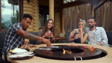 Odaklanmış adam dışarıdaki barbeküye tuz koyuyor. Izgaraya tuz döken adam