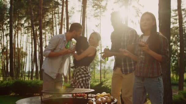 Weseli przyjaciele tańczący na imprezie BBQ w lesie. Kobieta trzymająca psa na zewnątrz — Wideo stockowe