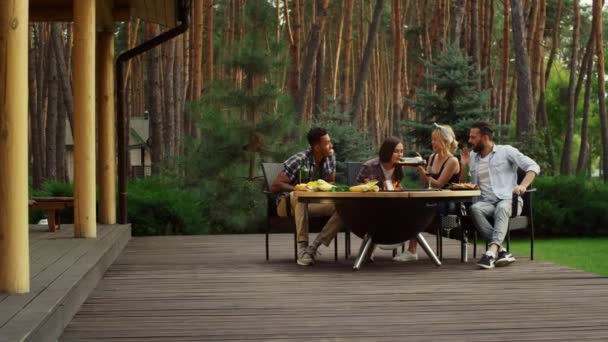 Gericht vrienden koken voedsel op de achtertuin. Serieus meisje houden vis buiten — Stockvideo