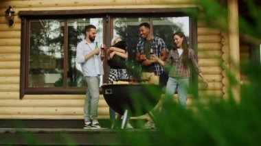 Dışarıdaki köpekle eğlenen oyuncu arkadaşlar. Erkek kadın için şarap veriyor.