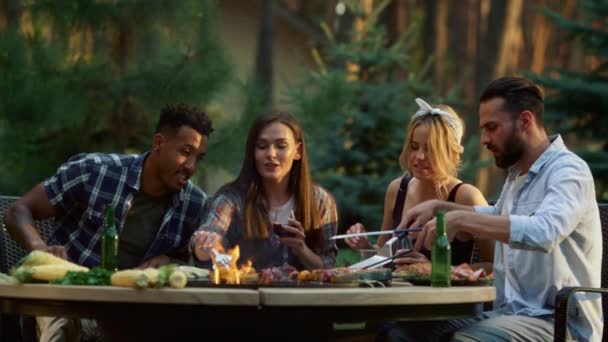 Cheerful friends relaxing on grill party in forest. Friends relaxing on party — Stock Video