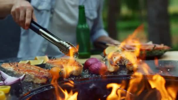 Unrecognizable man cooking fish on grill outside. Chef finishing cooking process — Stock Video