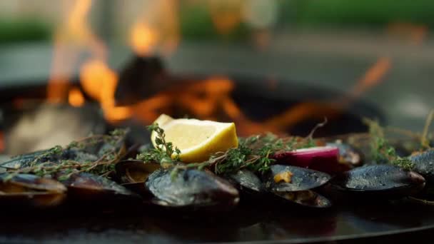 Mosselen in schelpen bereiden zich buiten voor. Zeevruchten bruinen op grill buiten — Stockvideo