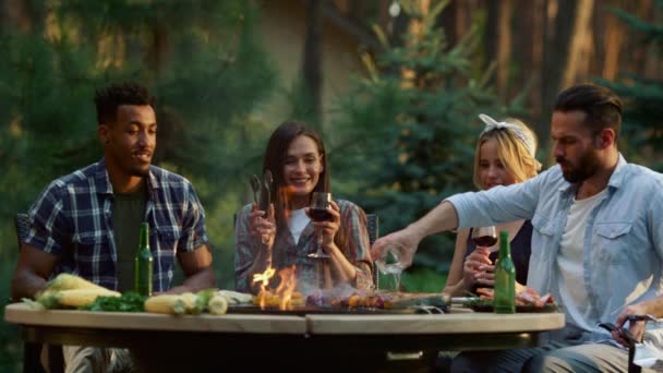 Focused man pouring oil on food outdoors. Friends getting scared of fire — Stock Video