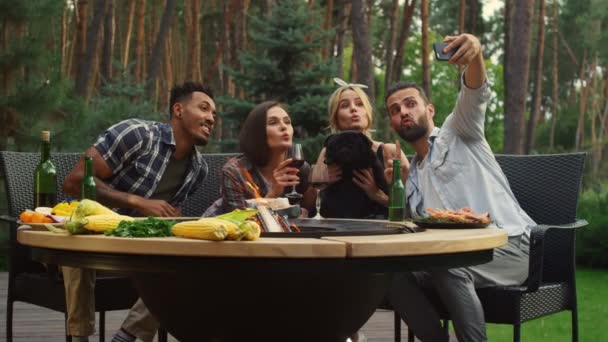 Cheerful friends posing on smartphone camera on backyard. Fellows making selfie — Stock Video