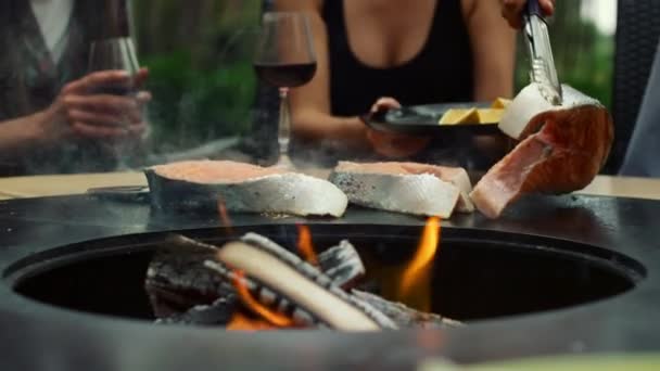 Onherkenbare man die vis kookt in de achtertuin. Chef-kok handen bereiden bbq voedsel — Stockvideo