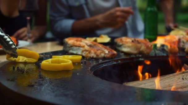 Onherkenbare man die buiten kookt. Chef zet ui en peper op grill — Stockvideo