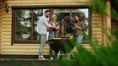 bbq Grill yakınlarında çok ırklı insanlar var. Partide bardakları tokuşturanlar