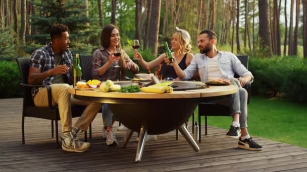 Cheerful people talking outside. Positive fellows clinking glasses on bbq party — Stock Video