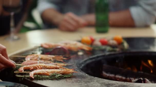 不认识的人把虾放在外面的烤架上烤.在网格上烹饪海鲜的女人 — 图库视频影像