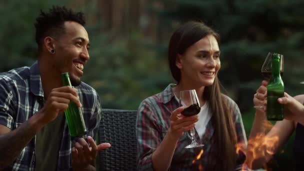 Casais sorridentes a conversar lá fora. Amigos felizes contando histórias no quintal. — Vídeo de Stock