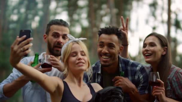 Gente feliz haciendo fotos de grupo en el bosque. Alegre amigos posando cámara — Vídeo de stock